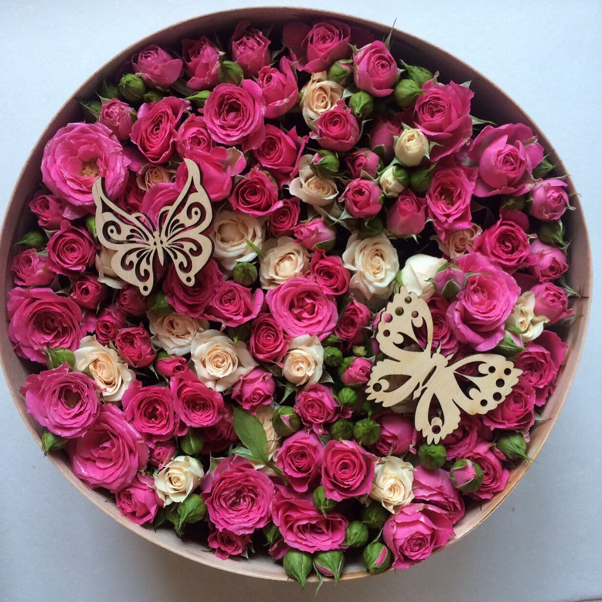 Круглая коробка с нежными розами в сочетании с деревом