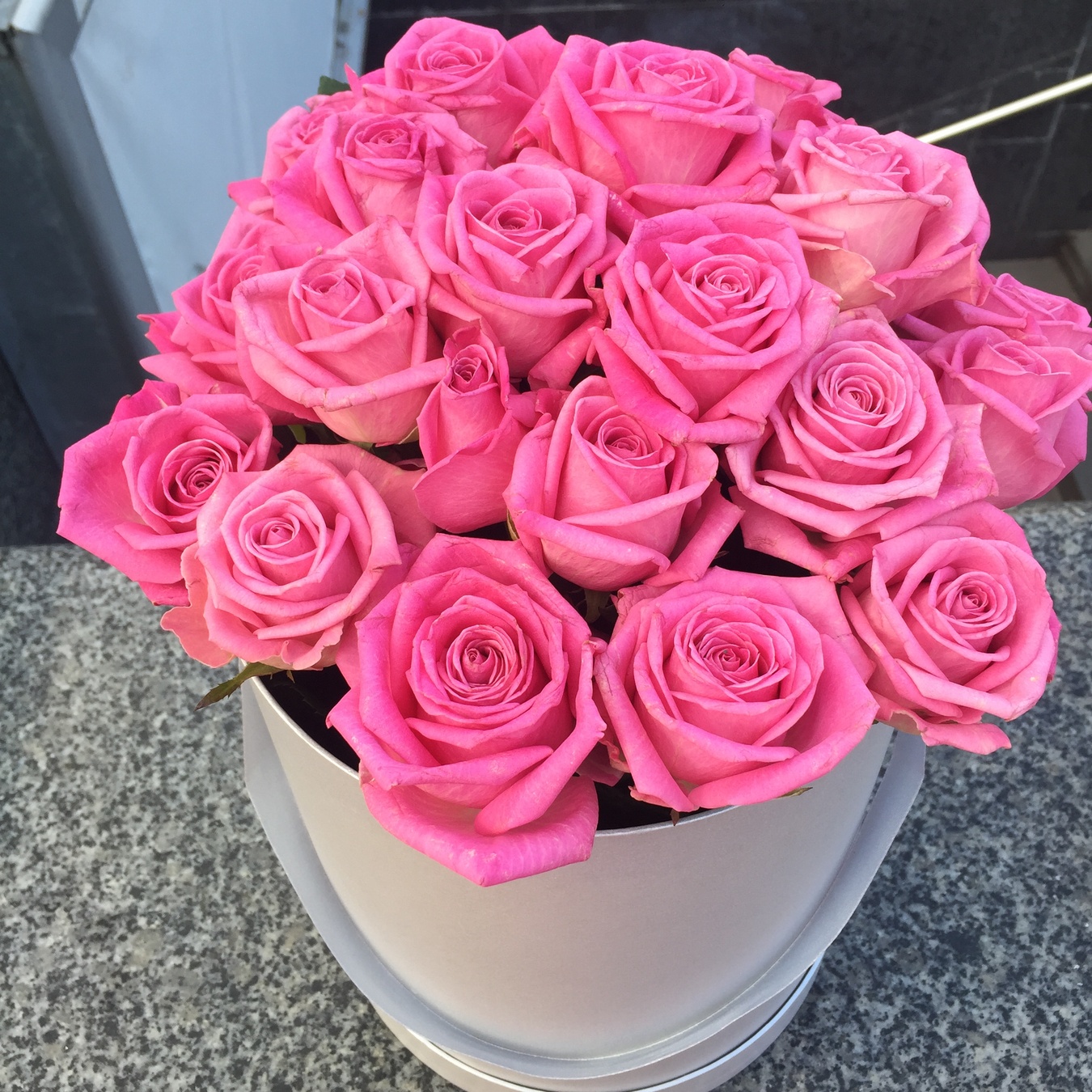 Прекрасні рожеві троянди в капелюшній коробці