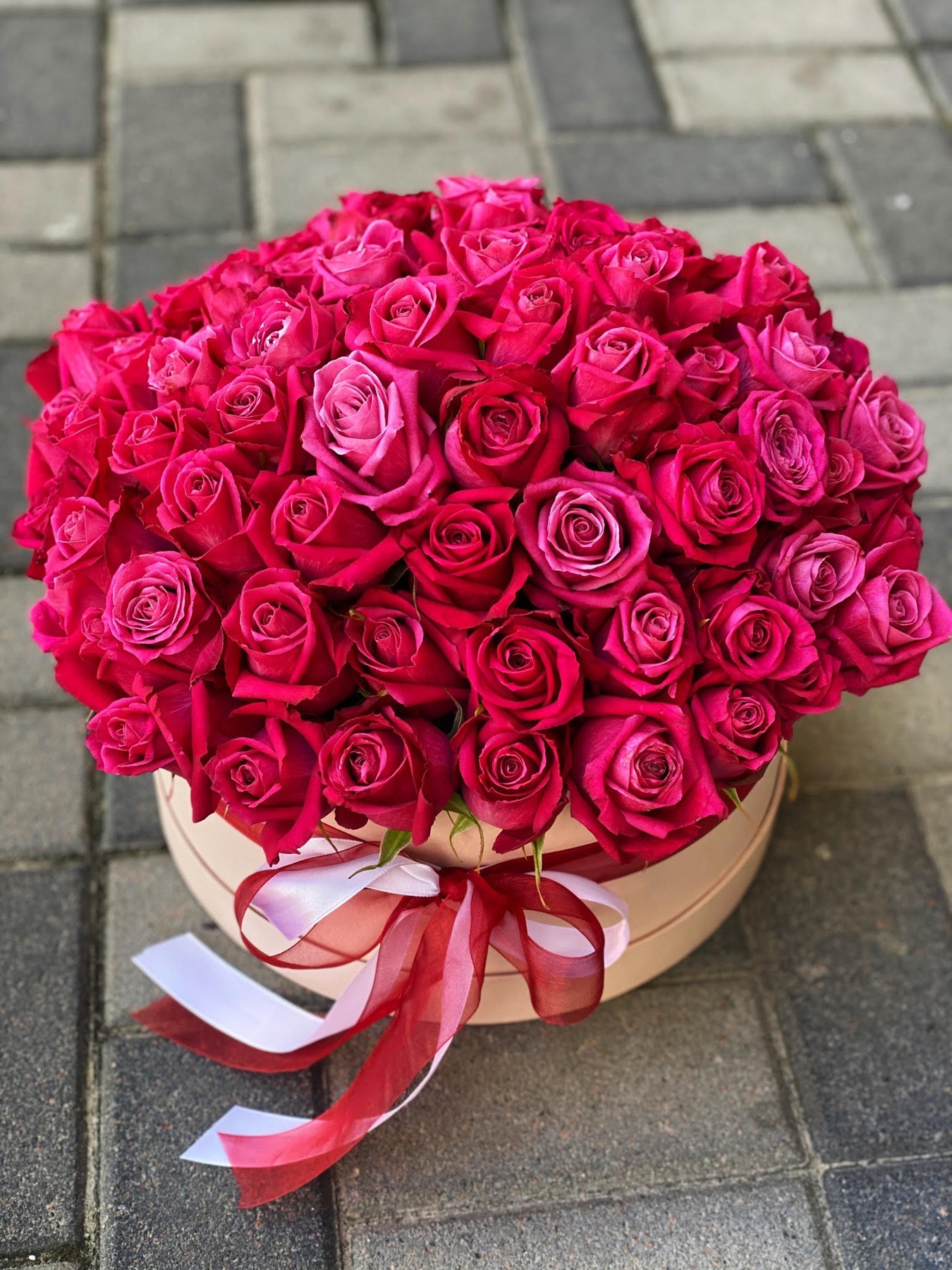 Кругла коробка з малиново-червоними трояндами