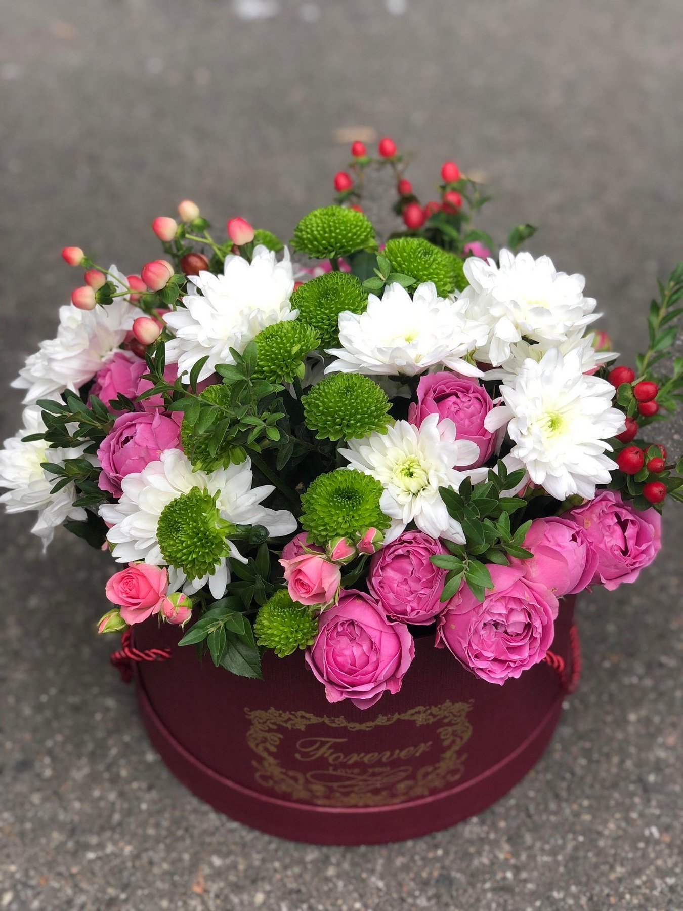 Квіти в круглій коробці з піоновидною трояндою, зеленою і білою хризантемою