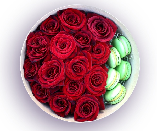 Червоні троянди і макаруни в круглій коробці