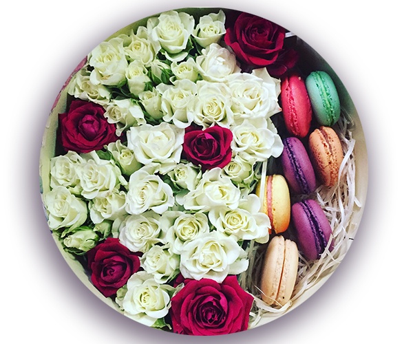 Кустовая кремовая и красная роза в круглой коробке с макарунами