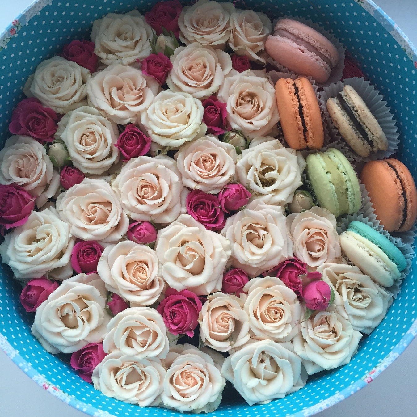 Кустовая кремовая и розовая роза с макарунами в круглой коробке